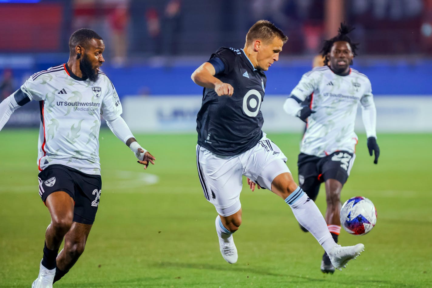 Minnesota United midfielder Robin Lod, center, receives the ball as FC Dallas defender Sebastien Ibeagha, left, defends during the first half