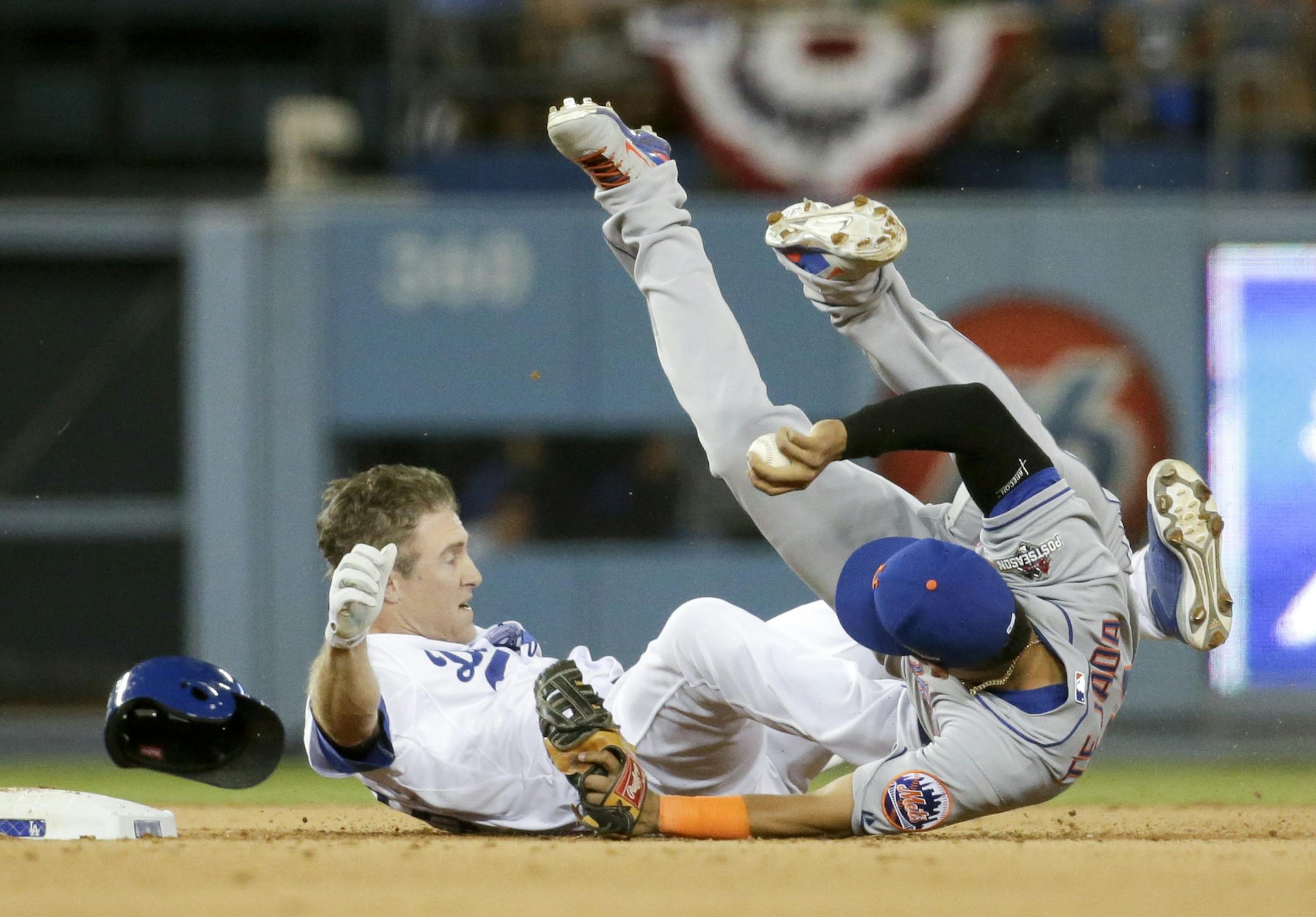 New York Mets shortstop Ruben Tejada, goes over the top of Los Angeles Dodgers' Chase Utley who broke up a double play during the seventh inning in Game 2 of baseball's National League Division Series, Saturday, Oct. 10, 2015 in Los Angeles. (AP Photo/Gregory Bull)