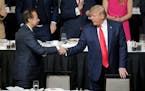 FILE - President Donald Trump, right, shakes hands with John Paulson during a meeting of the Economic Club of New York in New York, Nov. 12, 2019.