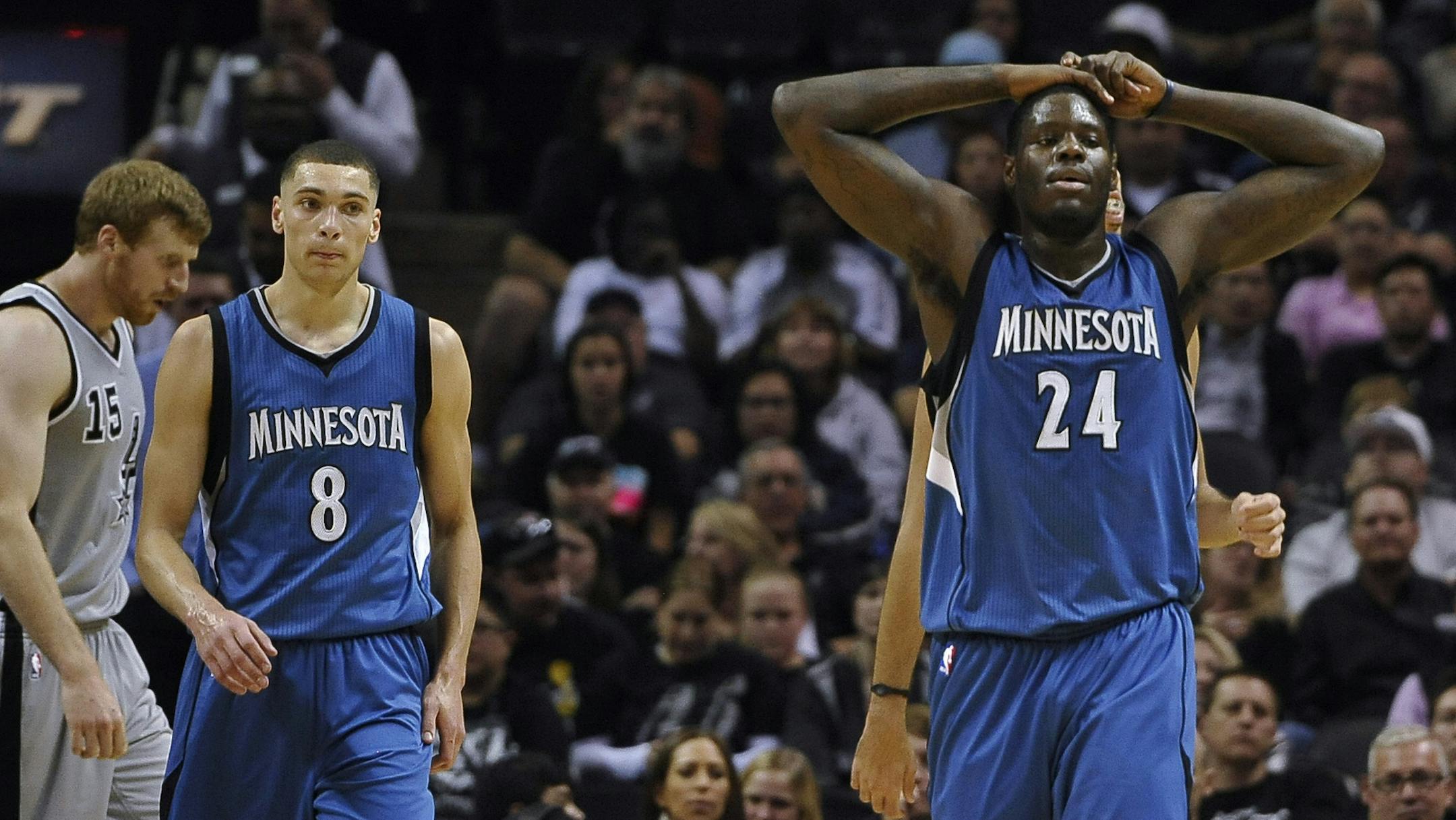 Minnesota Timberwolves' Anthony Bennett, right, and Zach LaVine, walk on the court during the second half of an NBA basketball game against the San Antonio Spurs, Saturday, Dec. 6, 2014, in San Antonio. San Antonio won 123-101. (AP Photo/Darren Abate)