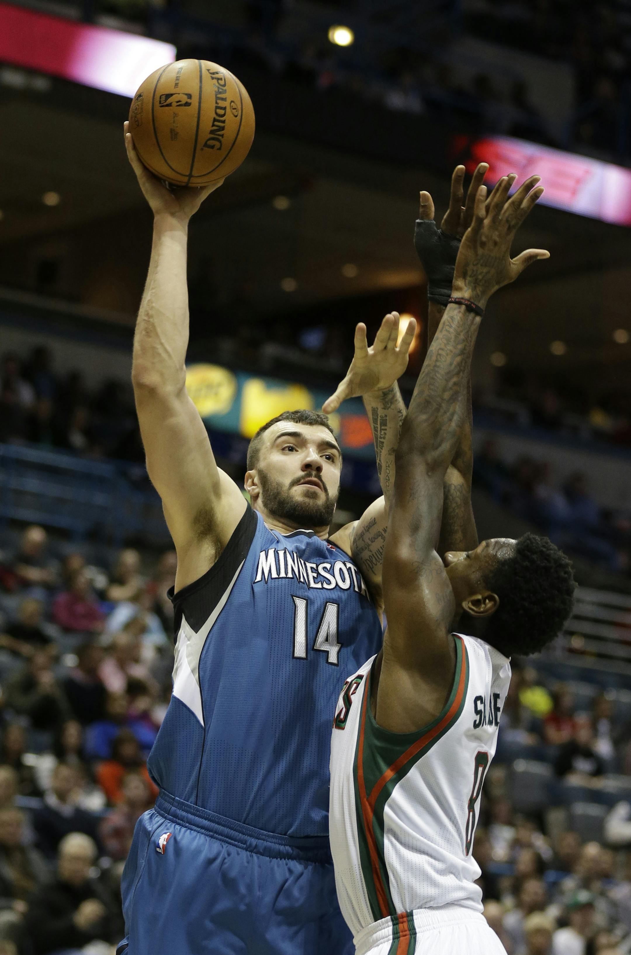 Minnesota Timberwolves' Nikola Pekovic (14) puts up a shot against Milwaukee Bucks' Larry Sanders, right, during the first half of an NBA basketball game, Saturday, Dec. 28, 2013, in Milwaukee. (AP Photo/Jeffrey Phelps)