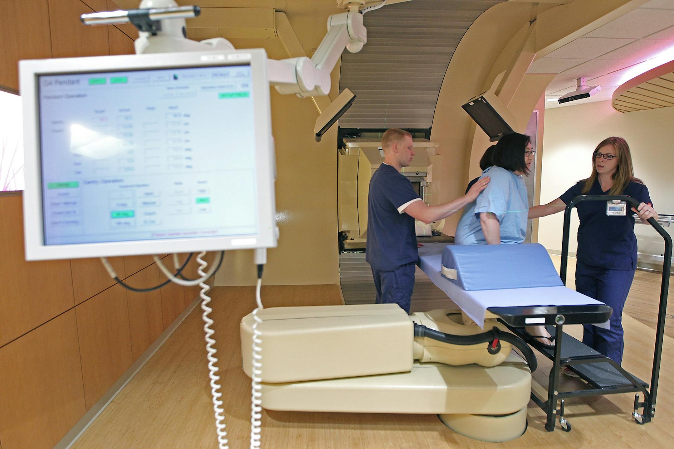 Radiation therapist Charlie Adams, left, and Katie Voigt, adjust patient Ashley Sullivan onto a device for a proton beam therapy, Monday, June 22, 2015 at Mayo Clinic in Rochester, MN.
