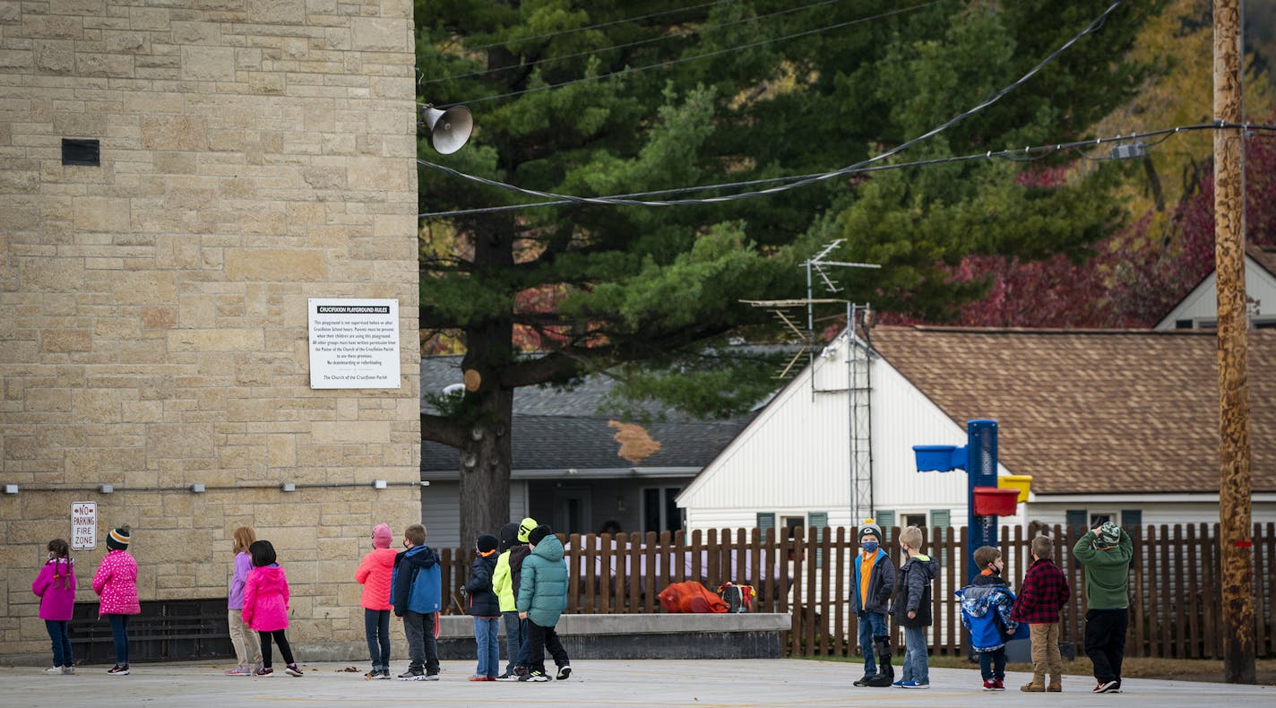 Children lined up outside while masked and socially-distanced at Crucifixion Catholic School in La Crescent. ] LEILA NAVIDI • leila.navidi@startribune.com BACKGROUND INFORMATION: Houston County in southeastern Minnesota on Wednesday, October 21, 2020. As COVID-19 continues to spread across the country, rural areas are being hit harder than ever before, Houston County included. In the past six weeks, the case count has more than doubled and the virus claimed its first victim.