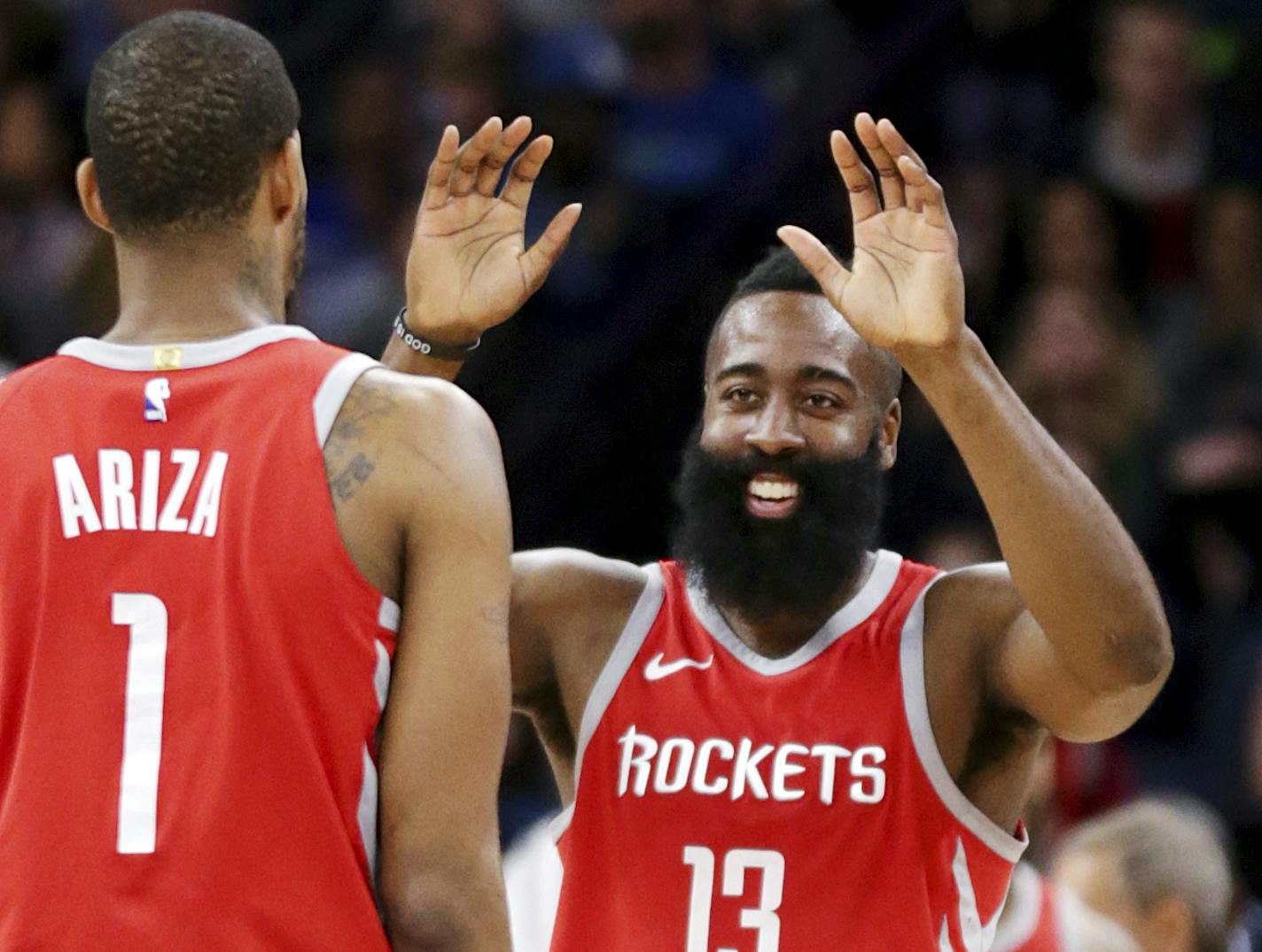 Houston Rockets James Harden (13) celebrates with teammate Trevor Ariza (1) after hitting a three-point shot against the Minnesota Timberwolves in the fourth quarter of an NBA basketball game Sunday, March 18, 2018, in Minneapolis. The Rockets defeated the Timberwolves 129-120. (AP Photo/Andy Clayton-King)