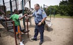 St. Paul Police officer Rob Zink visits with Devont'e Ray-Burns, 12, who has autism and other disabilities, outside Ray-Burns' home in St. Paul on Thu