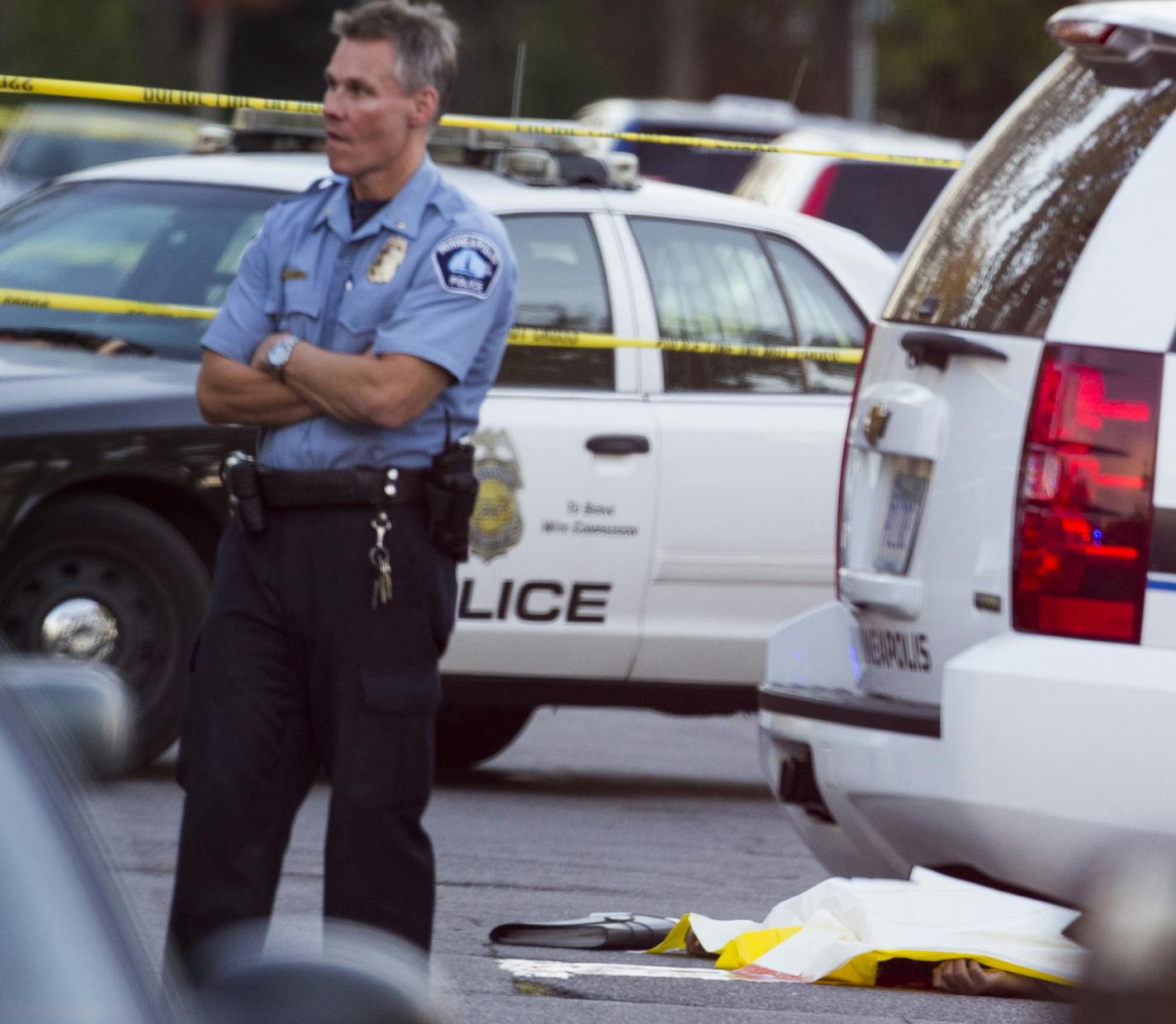 Minneapolis Police investigate the scene of a fatal shooting, the hand of the shooting victim can be seen under a white covering, on Pleasant Avenue south of Lake Street in Minneapolis on Monday, October 19, 2015. ] (LEILA NAVIDI/STAR TRIBUNE) leila.navidi@startribune.com