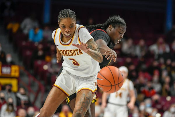 Maryland guard Ashley Owusu, right, knocks the ball away from Minnesota guard Deja Winters during the first half an NCAA college basketball game Sunda
