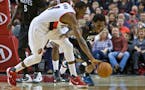 Portland forward Al-Farouq Aminu, left, and Timberwolves guard Andrew Wiggins dived for a loose ball during the second half of Sunday night's game. Wi