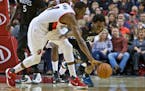 Portland forward Al-Farouq Aminu, left, and Timberwolves guard Andrew Wiggins dived for a loose ball during the second half of Sunday night's game. Wi