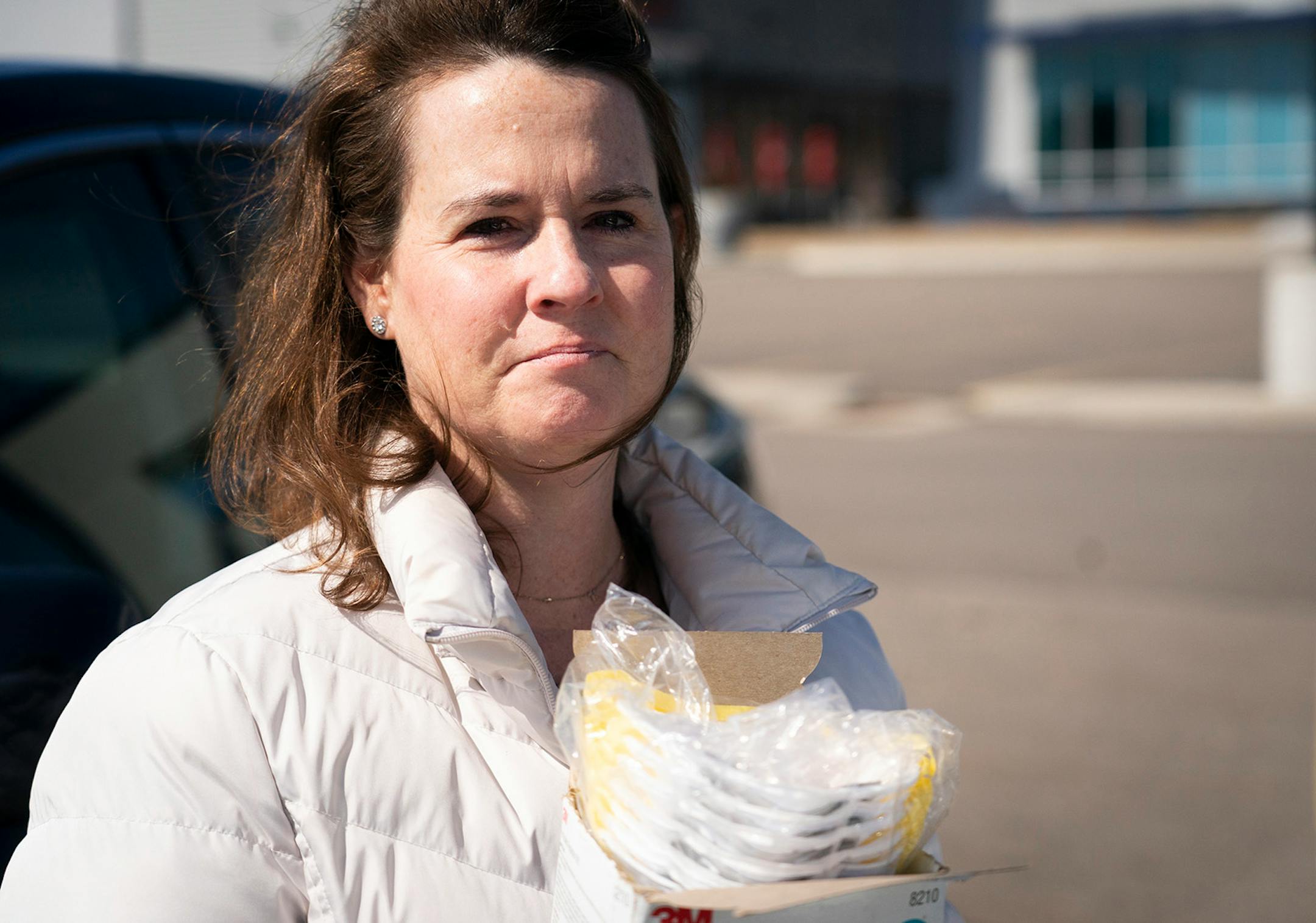 Kara Spike, a nurse at the COVID-19 unit at St. Joseph's Hospital in St. Paul, had a tear streaming down her face after she collected a box of respirator masks her brother had donated to her and her colleagues from his auto mechanic job in Minnetonka, Minn., on Friday, March 20, 2020.