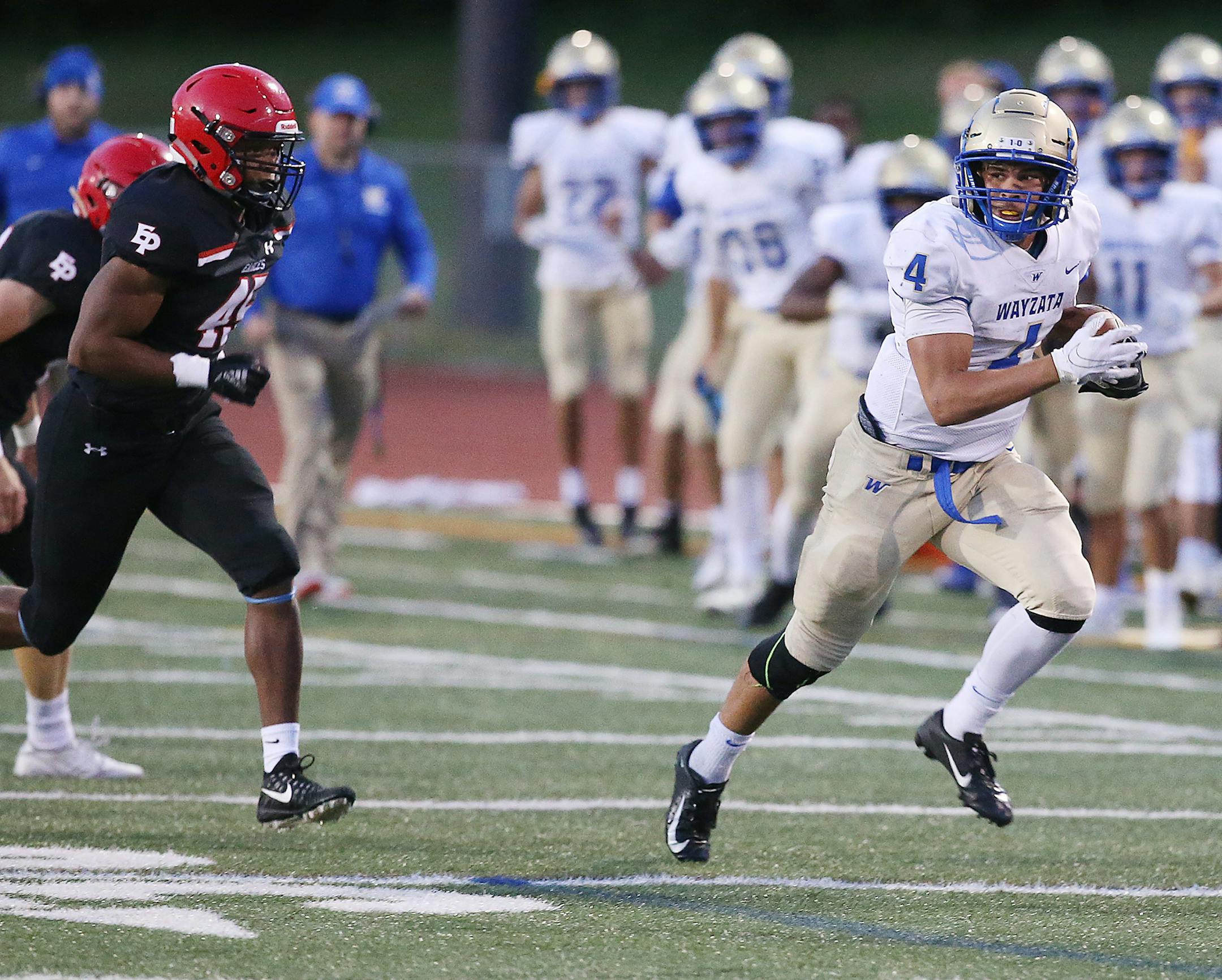 Wayzata running back Christian Vasser (4) turned it outside and up the field for a long run, eluding Eden Prairie tackler Justice Sullivan (45) during the first half.] DAVID JOLES • david.joles@startribune.com Wayzata at Eden Prairie High School Friday, Sept. 27, 2019, in Eden Prairie,MN.