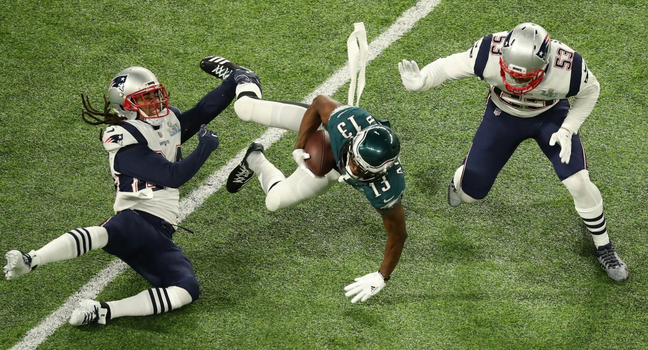 Philadelphia Eagles wide receiver Nelson Agholor (13) fell forward during the Eagles' first drive as Stephon Gilmore, left, and Kyle Van Noy defended in Super Bowl LII.