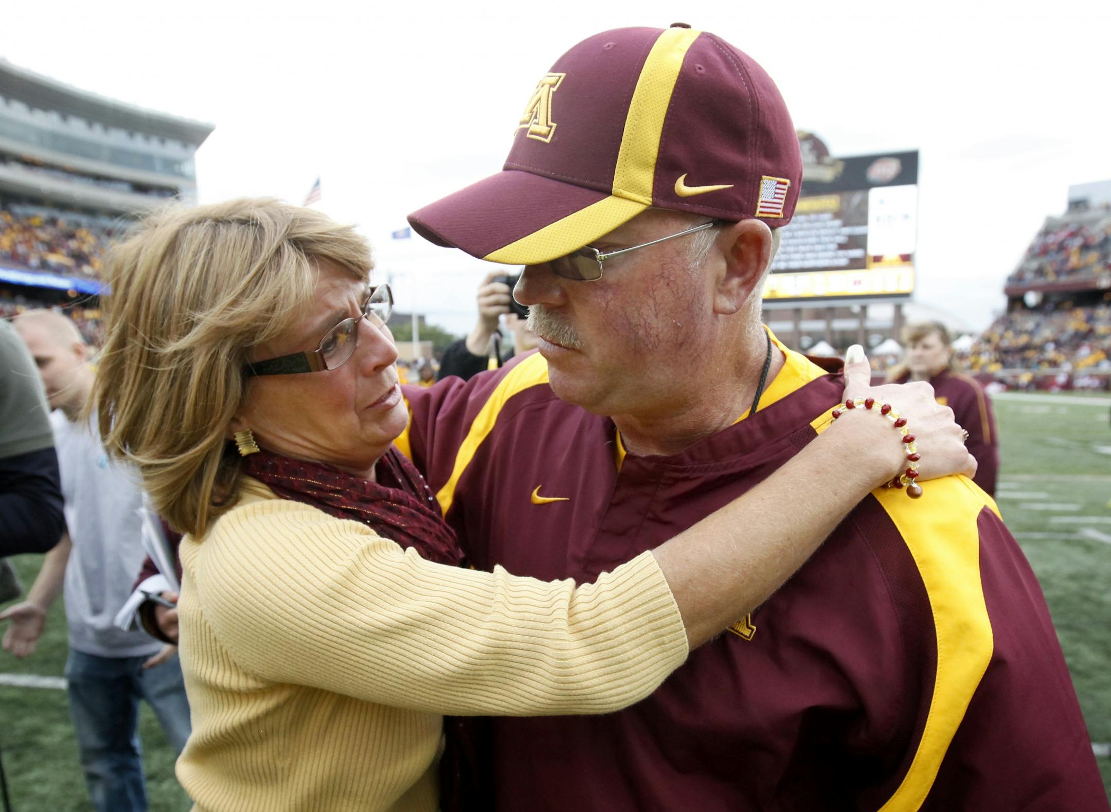 Minnesota head football coach Jerry Kill got a hug and kiss from his wife Rebecca at the end of the game. Minnesota beat Miami by a final score of 29 – 23. The win was Kill's first as coach of the Gophers.