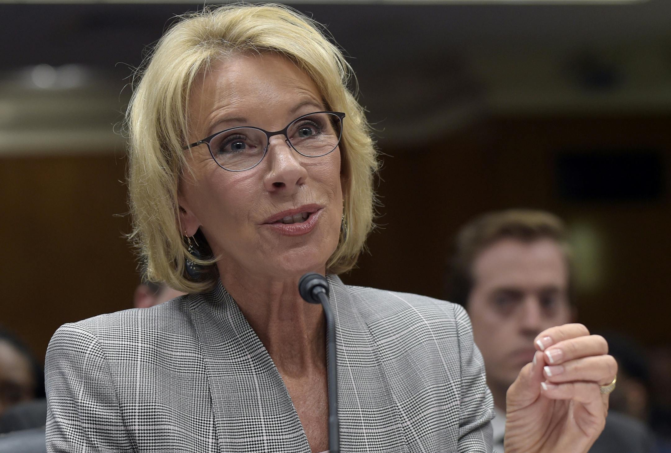 FILE - In this June 6, 2017, file photo, Education Secretary Betsy DeVos testifies on Capitol Hill in Washington before the Senate Appropriations Committee, Labor, Health and Human Services, Education, and Related Agencies Subcommittee hearing on the fiscal year 2018 budget. Democratic attorneys general in 18 states and the District of Columbia are suing Education Secretary Betsy DeVos over her decision to suspend rules meant to protect students from abuses by for-profit colleges. The lawsuit wa