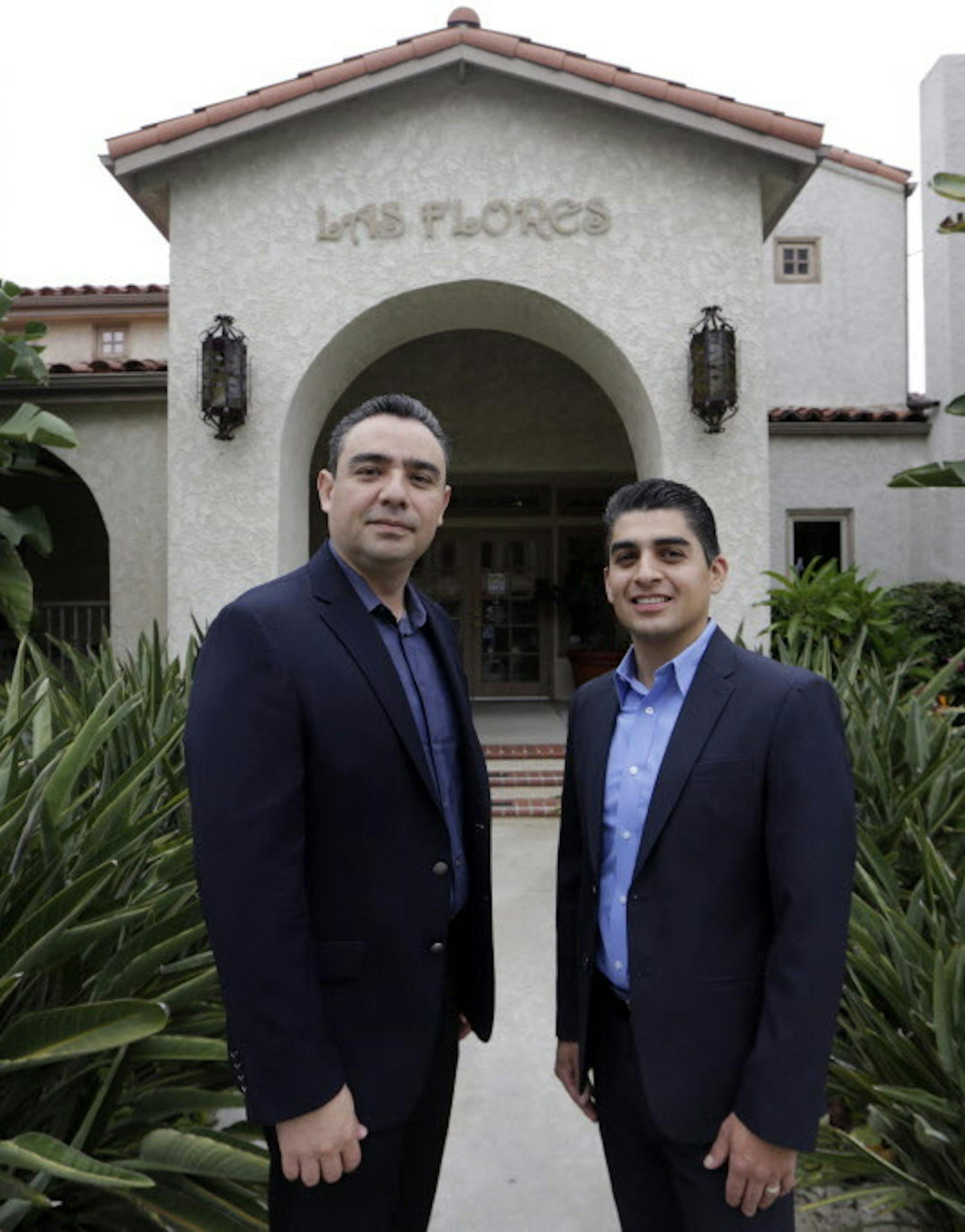 In this Friday, Aug. 21, 2015 photo, certified financial planners Aaron Munoz, left, and Gilbert Cerda pose for a photo at their offices in Downey, Calif. Their company, Cerda Munoz Advisors, offers financial advice with a focus on the Hispanic population. (AP Photo/Damian Dovarganes)