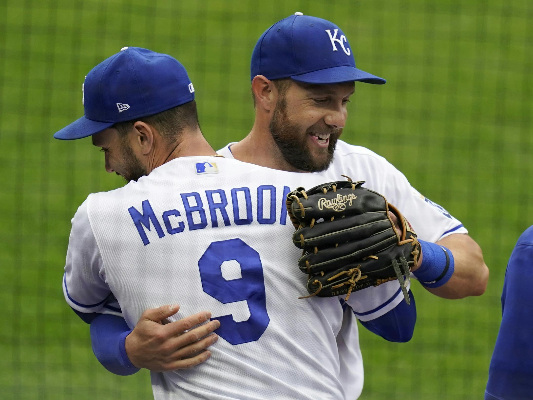 Kansas City Royals left fielder Alex Gordon, middle, is hugged by teammate Ryan McBroom (9) after being taken out of a baseball game against the Detroit Tigers during the second inning at Kauffman Stadium in Kansas City, Mo., Sunday, Sept. 27, 2020. It was Gordon's last game as a Royal. (AP Photo/Orlin Wagner)