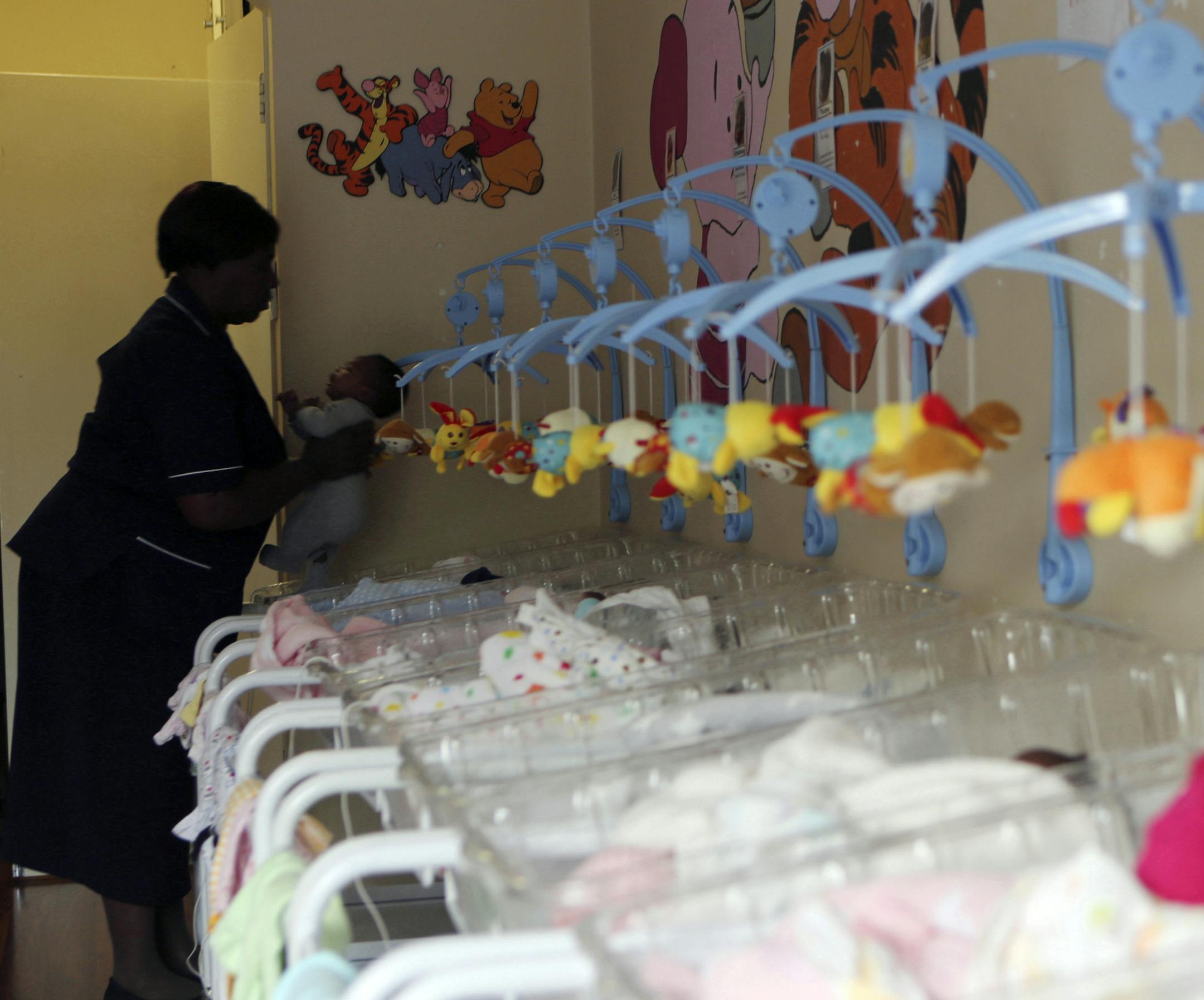 In this photo taken Wednesday, Feb. 1, 2017, a caregiver takes a newly abandoned baby out of it's crib at the Door of Hope in Johannesburg. The sanctuary was started 17 years ago to provide a safe place where babies could be abandoned by their mothers. Sixty-four babies were taken in by the center in 2016 and 43 percent of those were adopted. The rest are cared for and eventually go to orphanages, said the organization, which receives funding from the governmentís social welfare department