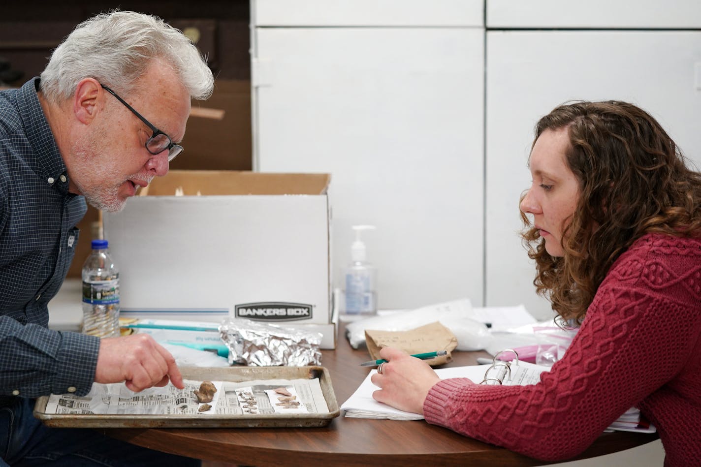 Volunteer Larry Macht and archaeologist Kelly Wolf cleaned and bagged artifacts unearthed during trail construction on Coney Island in Lake Waconia.