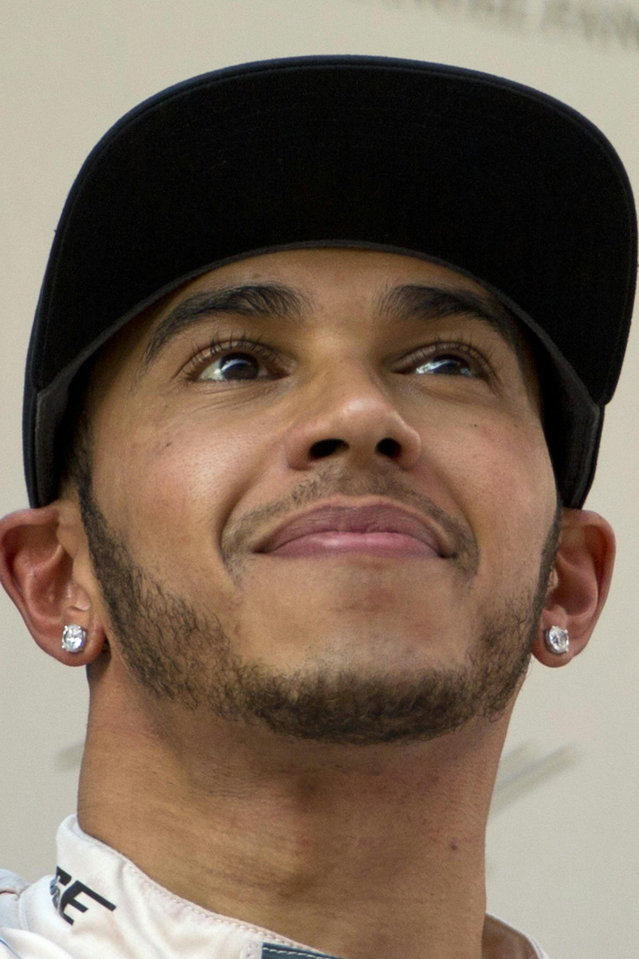 Mercedes driver Lewis Hamilton of Britain holds up his trophy on the podium after winning the Chinese Formula One Grand Prix at Shanghai International Circuit in Shanghai, China, Sunday, April 12, 2015. (AP Photo/Mark Schiefelbein)