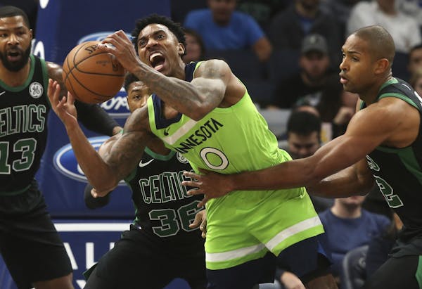 Minnesota Timberwolves' Jeff Teague, center, is grabbed by Boston Celtics' Al Horford, right, during the first half of an NBA basketball game Saturday