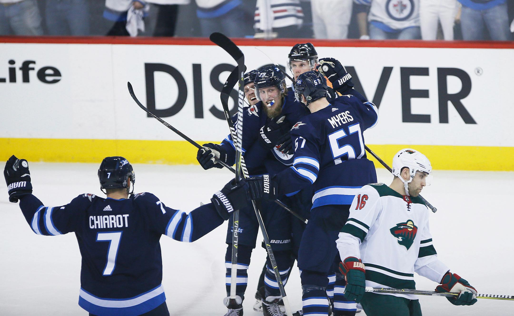 Winnipeg Jets' Ben Chiarot (7), Nikolaj Ehlers (27), Patrik Laine (29) and Tyler Myers (57) celebrate Laine's goal as Minnesota Wild's Jason Zucker (16) skates by during third period game two NHL playoff action in Winnipeg on Friday, April 13, 2018. THE CANADIAN PRESS/John Woods/The Canadian Press via AP)