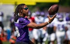 Minnesota Vikings wide receiver Justin Jefferson (18) tossed a ball to himself during training camp. Jefferson was at practice without a helmet and pa