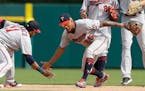 Minnesota Twins center fielder Byron Buxton (25) and shortstop Jorge Polanco (11) celebrate a win over the Detroit Tigers in a baseball game, Sunday, 