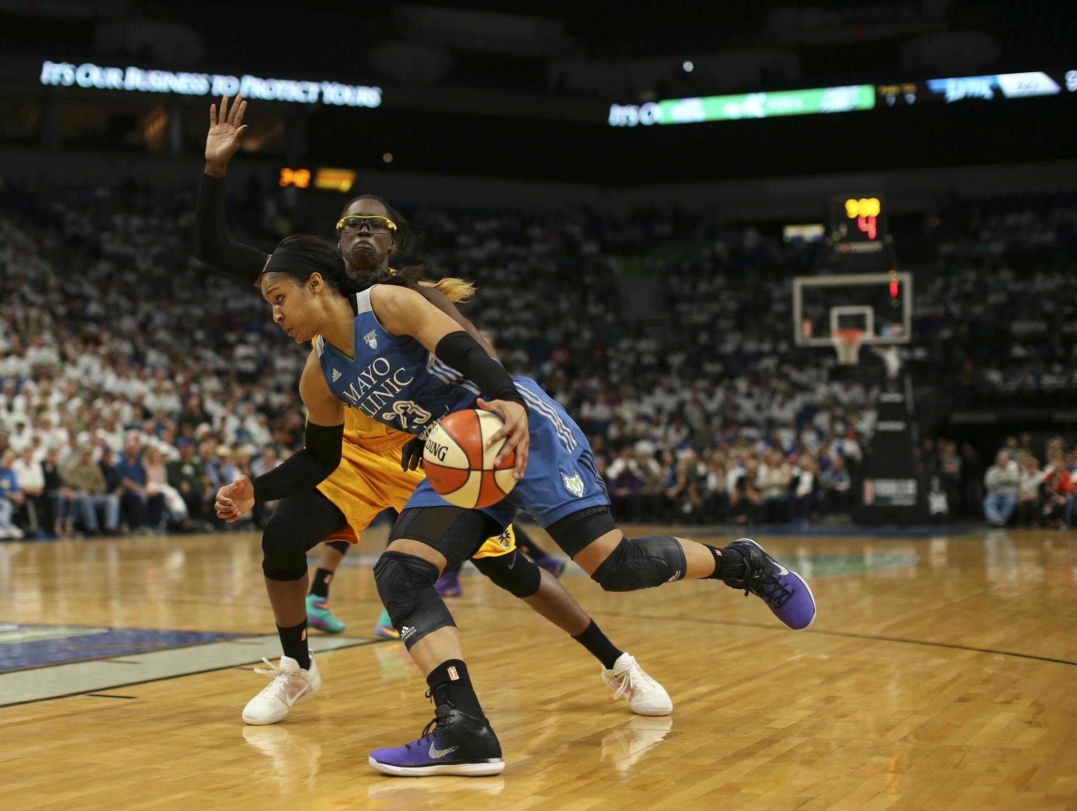 Minnesota Lynx forward Maya Moore (23) drove to the net against the defense of Los Angeles Sparks forward Essence Carson (17).