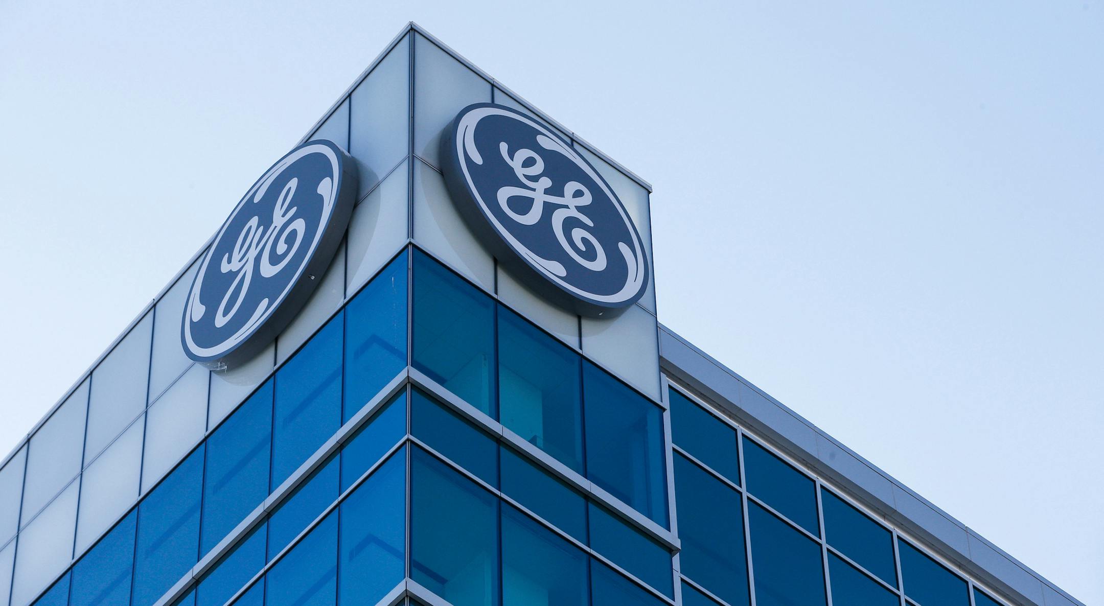 FILE- In this Jan. 16, 2018, file photo, the General Electric logo is displayed at the top of their Global Operations Center in the Banks development of downtown Cincinnati. General Electric is joining with Wabtec Corp. in a cash-and-stock deal as part of a move to help bolster its transportation unit. (AP Photo/John Minchillo, File)