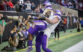 Vikings guard Dalton Risner (66) lifts Vikings wide receiver Brandon Powell (4) as they celebrate Powell's touchdown in the fourth quarter at Mercedes