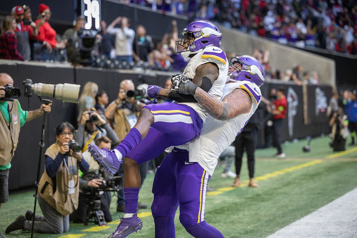 Vikings guard Dalton Risner (66) lifts Vikings wide receiver Brandon Powell (4) as they celebrate Powell's touchdown in the fourth quarter at Mercedes-Benz Stadium in Atlanta, Georgia, on Friday, Nov. 3, 2023. ] Elizabeth Flores • liz.flores@startribune.com