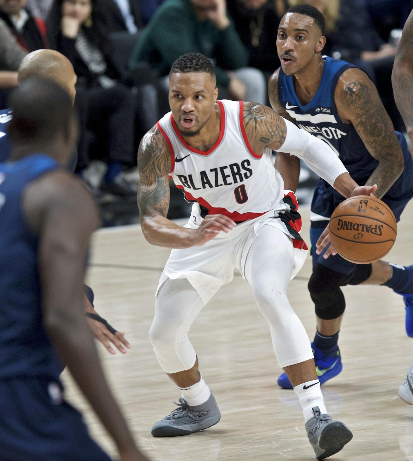 Portland Trail Blazers guard Damian Lillard dribbles as the Minnesota Timberwolves including guard Jeff Teague, right, watch during the second half of an NBA basketball game in Portland, Ore., Wednesday, Jan. 24, 2018. (AP Photo/Craig Mitchelldyer)