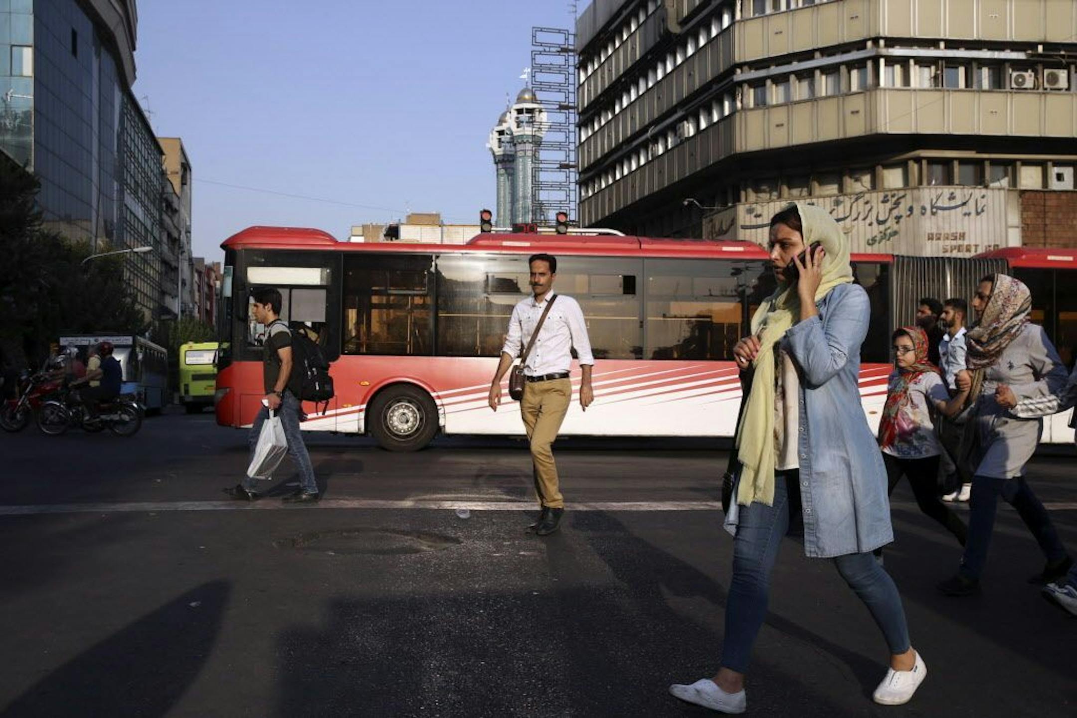 People cross Jomhouri-e-Eslami (Islamic Republic) St. in downtown Tehran, Iran, Monday, July 30, 2018. Iran's currency plummeted to a record low Monday, a week before the United States restores sanctions lifted under the unraveling nuclear deal, giving rise to fears of prolonged economic suffering and further civil unrest.