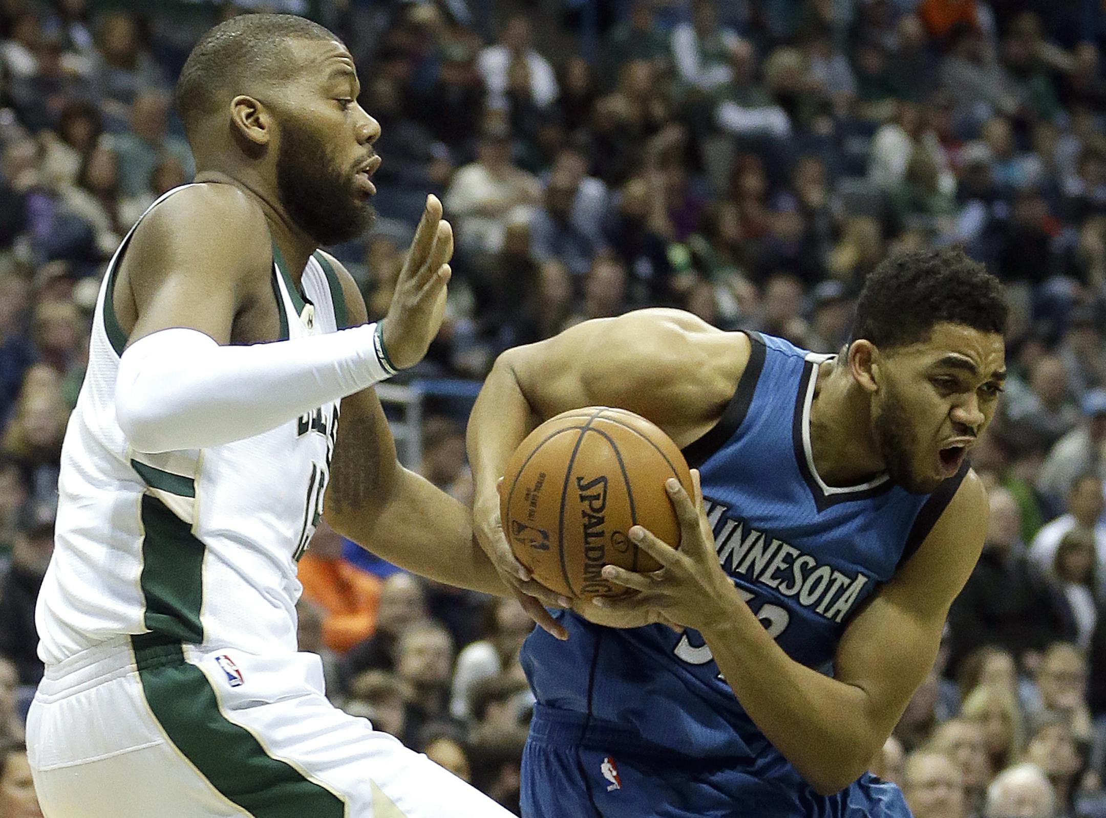 Minnesota Timberwolves' Karl-Anthony Towns, right, drives past Milwaukee Bucks' Greg Monroe during the first half of an NBA basketball game Saturday, March 11, 2017, in Milwaukee. (AP Photo/Aaron Gash)