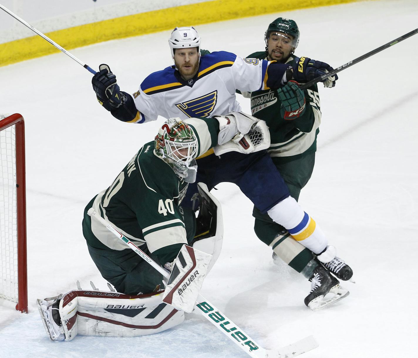 Minnesota Wild goalie Devan Dubnyk (40) clears St. Louis Blues center Steve Ott (9) and Wild defenseman Matt Dumba, right, away from the net during the third period of Game 3 of an NHL hockey first-round playoff series game in St. Paul, Minn., Monday, April 20, 2015. The Wild won 3-0. (AP Photo/Ann Heisenfelt) ORG XMIT: MIN2015042106172901