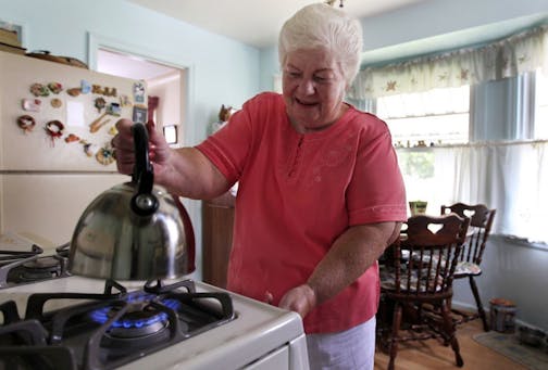 In this photo taken July 26, 2012, Marge Youngs adjusts the flame on her stove at her home in Toledo, Ohio. When given a choice on how to fix Social Security's serious long-term financial problems, 53 percent of adults said they would rather raise taxes than cut benefits for future generations, according to an Associated Press-GfK poll. "Right now, it seems like we're taxed so much, but if that would be the only way to go, I guess I'd have to be for it to preserve it," said Youngs, a 77-year-old