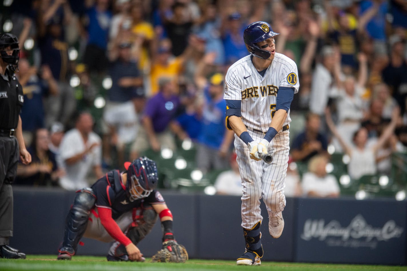 Milwaukee Brewers' Christian Yelich, right, watches his grand slam in the bottom of the eighth inning of a baseball game against the Washington Nationals, Saturday, Aug. 21, 2021, in Milwaukee. (AP Photo/Michael R. Schmidt)