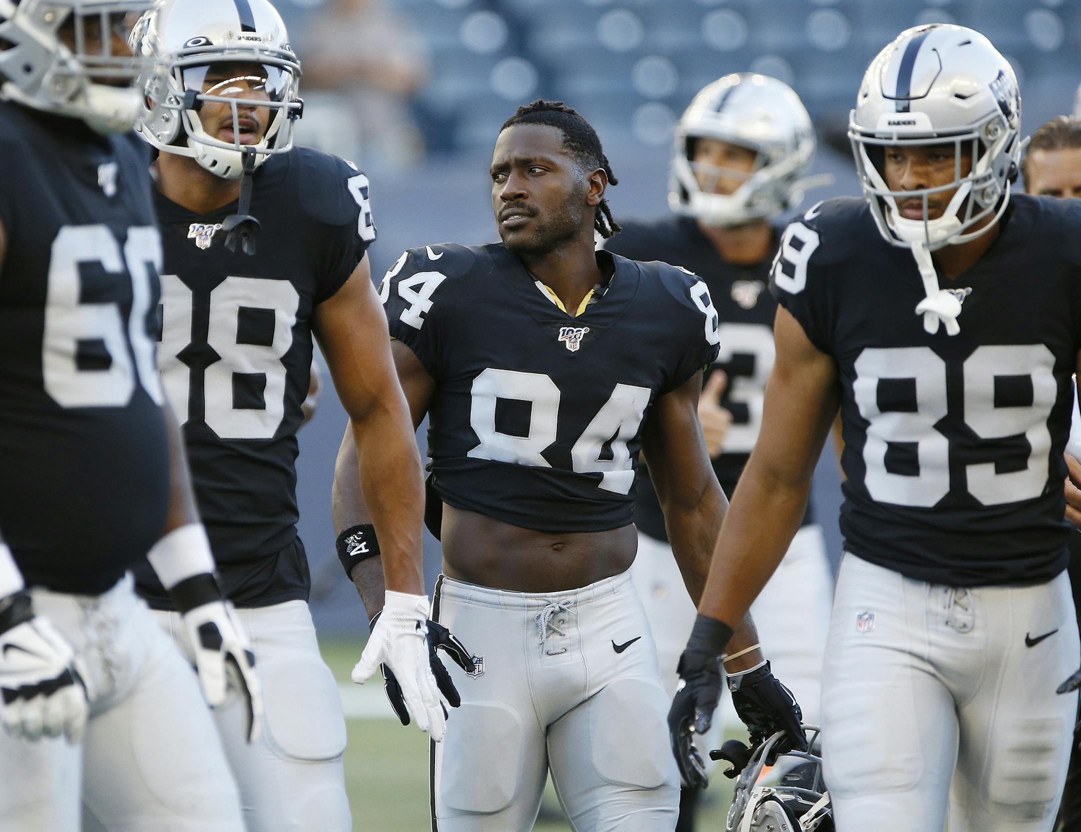 In this Aug. 22, 2019, file photo, Oakland Raiders' Antonio Brown (84) and teammates gather before an NFL preseason football game against the Green Bay Packers in Winnipeg. Brown was released by the Raiders and signed with New England.