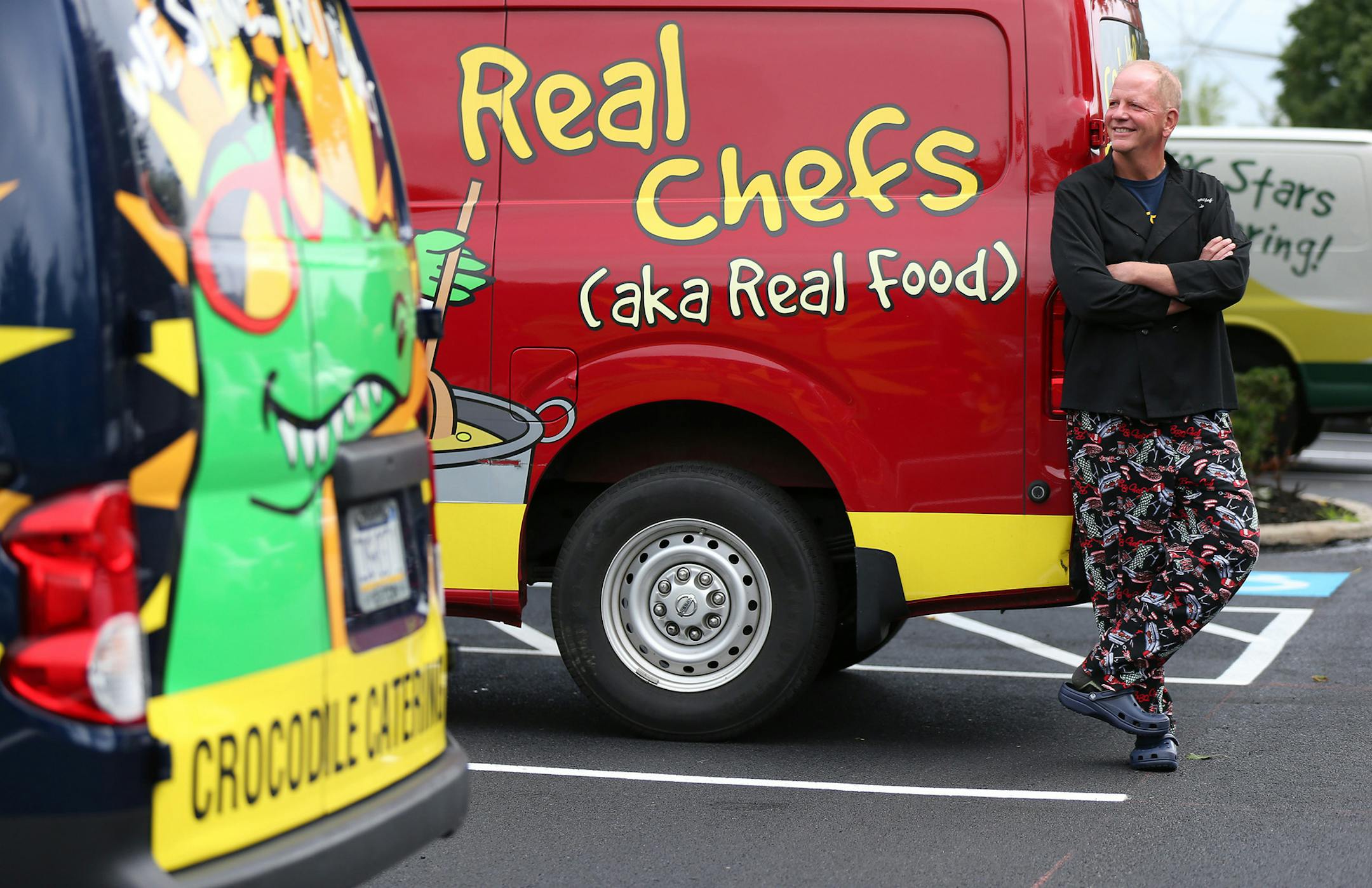 Kurt Linneman, chef and owner of Crocodile Cafe & Catering, poses with his colorful delivery trucks on July 14, 2015 in Wayne, Pa. (David Maialetti/Philadelphia Inquirer/TNS) ORG XMIT: 1171809