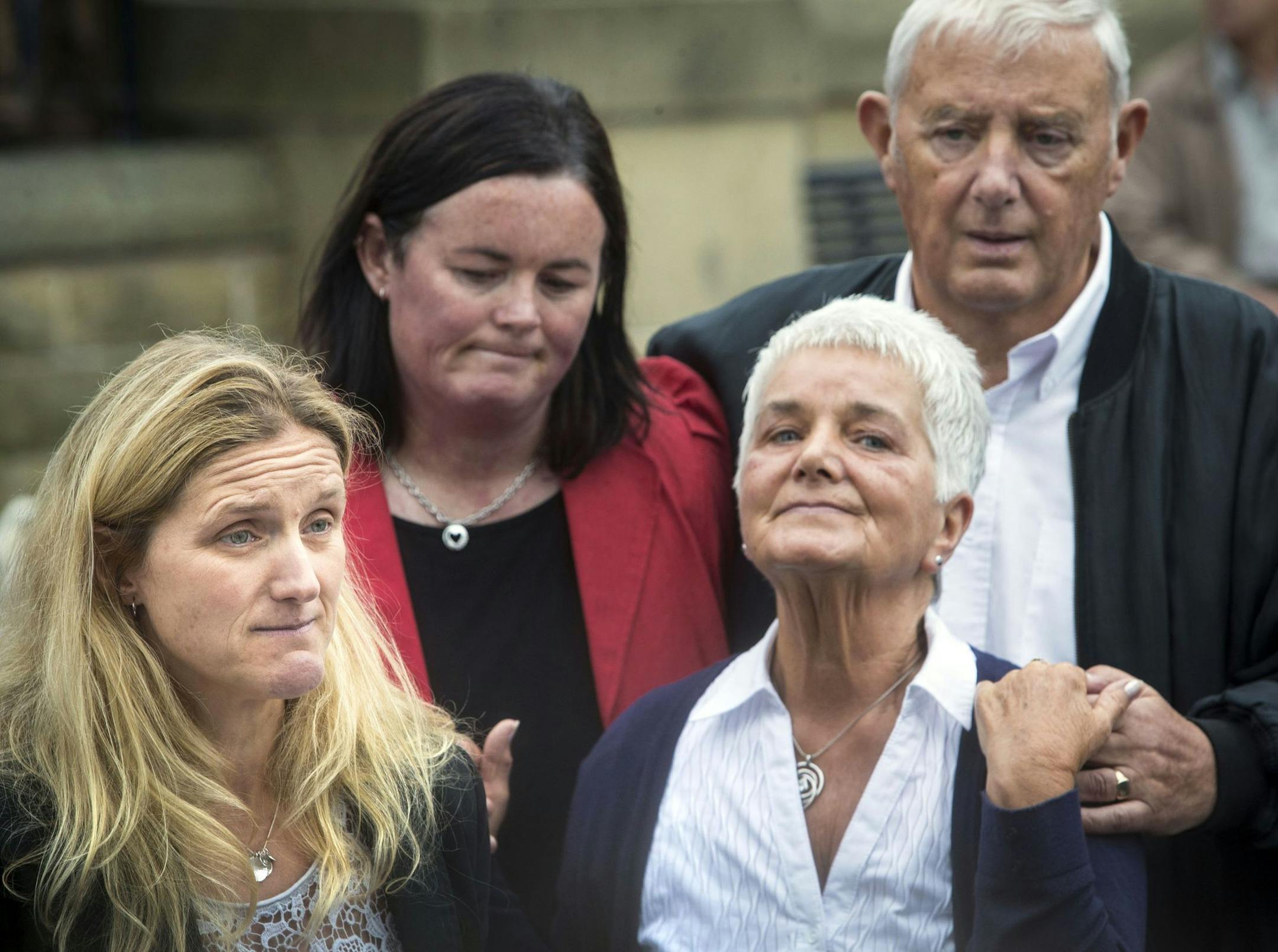 Kim Leadbeater, left, the sister of Labour Member of Parliament, Jo Cox, speaks to the media as she visited floral tributes with her parents Jean, right, and Gordon Leadbeater, rear right, in Birstall, northern England, Saturday June 18, 2016. The man accused of a murder that has brought campaigning in the country's European Union referendum to a standstill turned his first court appearance Saturday into a chilling spectacle by refusing to state his real identity. Jo Cox, 41, died after being sh