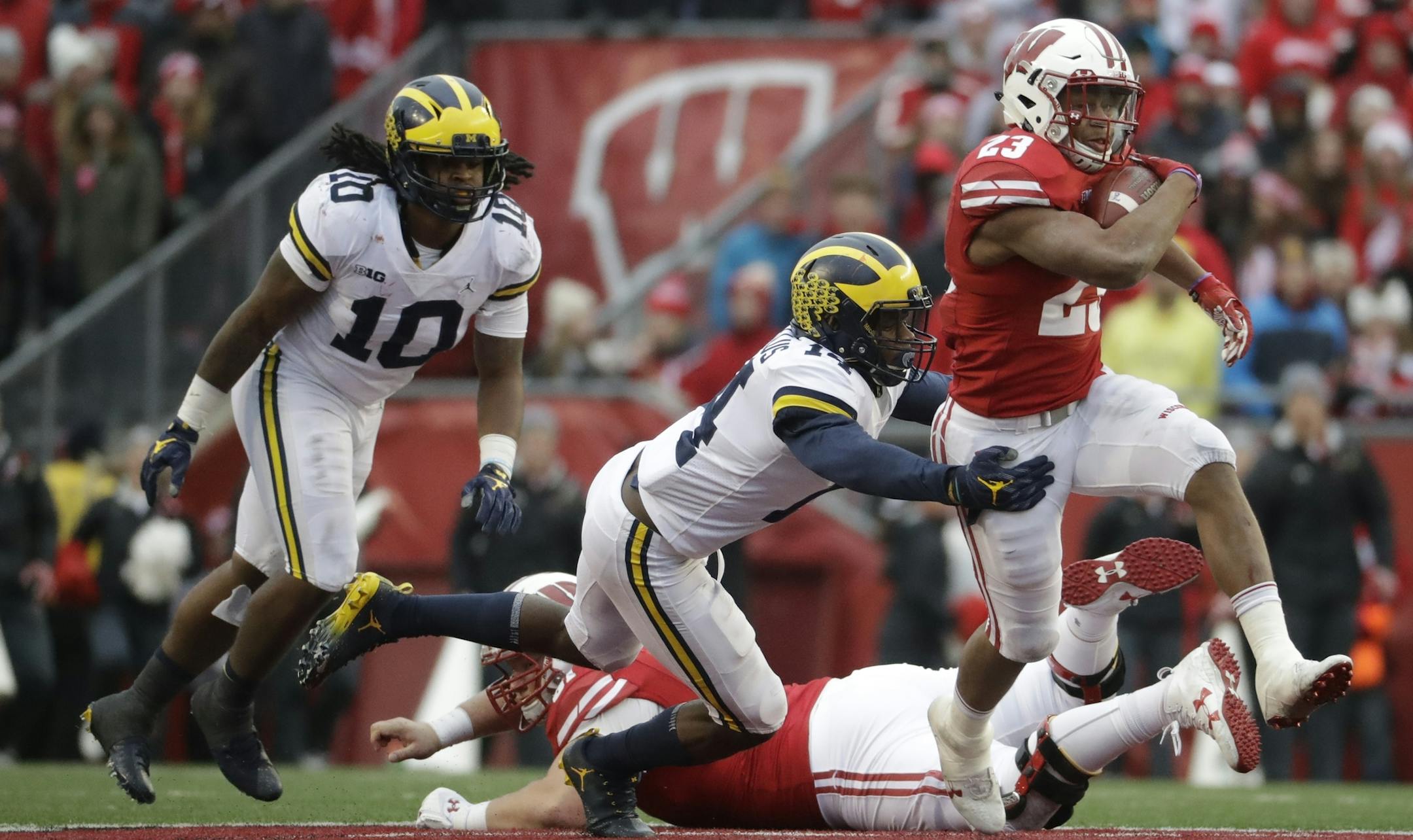 Wisconsin's Jonathan Taylor runs past Michigan's Josh Metellus during the second half of an NCAA college football game Saturday, Nov. 18, 2017, in Madison, Wis. (AP Photo/Morry Gash)