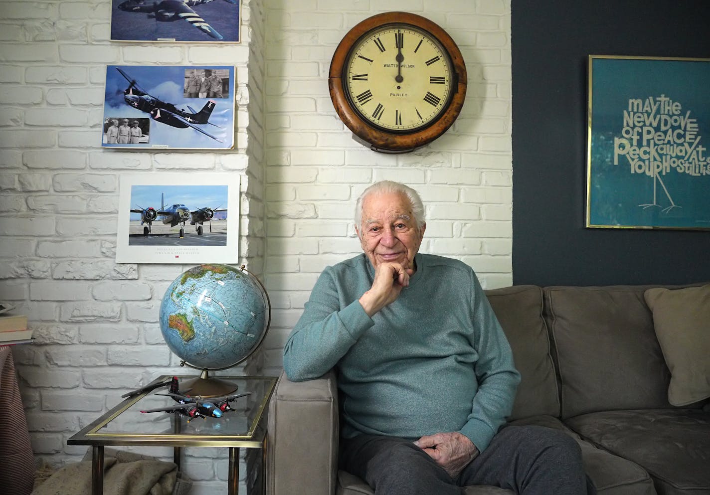 A man sits on a couch for a portrait.