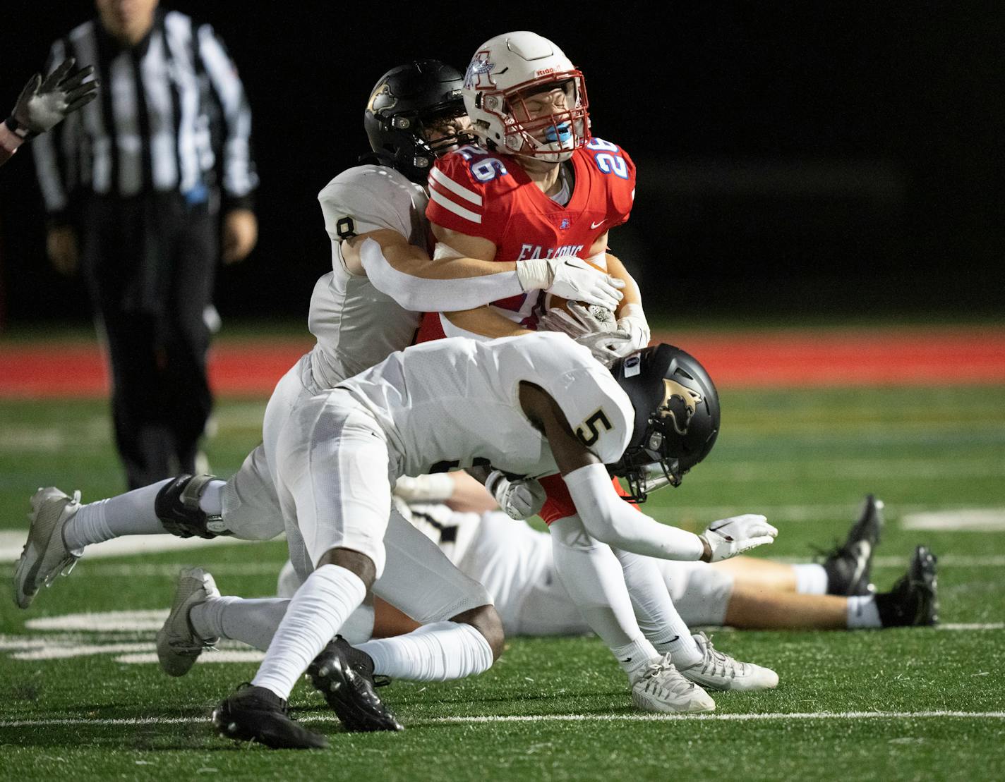 Armstrong's running back Jackson Wylie is stopped by Andover defense Ben Peterson (8) and Oberhiri Eyafe (5) in the first half. Robbinsdale Armstrong High School hosted Andover High School on Wednesday, Oct. 18, 2023 in Plymouth, Minn. ] RENEE JONES SCHNEIDER • renee.jones@startribune.com