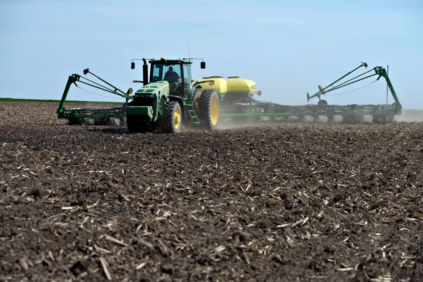 A Deere & Co John Deere 8130 tractor pulls a 24-row planter as corn is planted in Malden, Illinois, U.S., on Tuesday, May 6, 2014. This year's record advance in crop prices is drawing investors to U.S. agricultural funds for the first time since 2010. Exchange-traded products tracking farm commodities grew by $542.7 million since the end of last year to $2.5 billion as of May 2, data compiled by Bloomberg show. The 27 percent gain since Dec. 31 follows three years of declines. Photographer: Dani