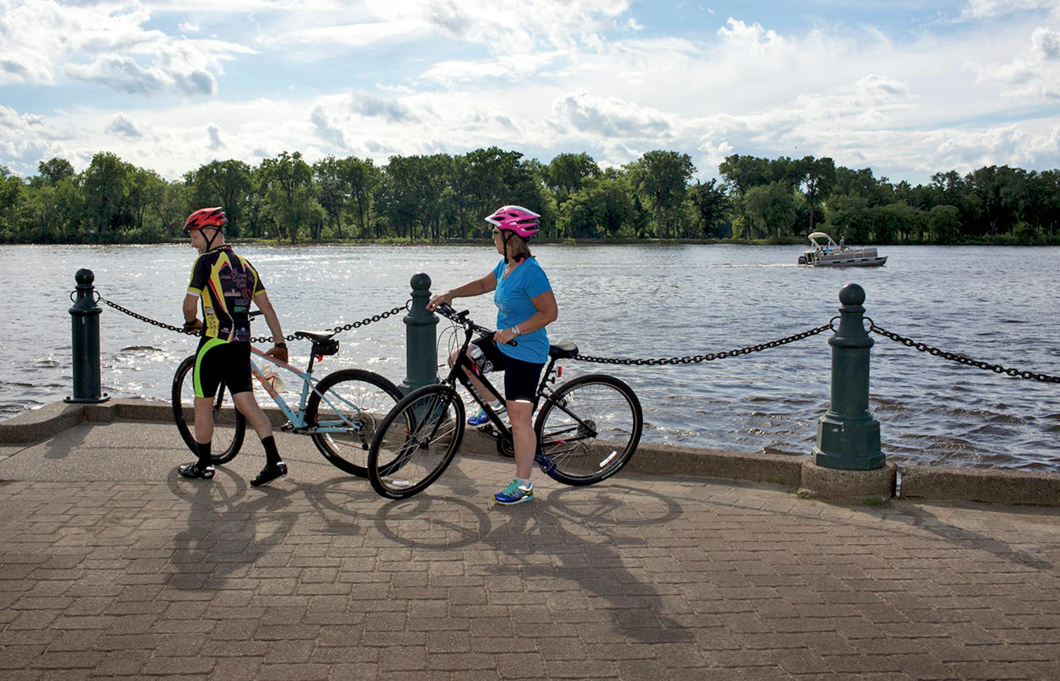 Lisa (right) and Paul Duckworth ride their bikes along the Mississippi River in La Crosse. ] COURTNEY PEDROZA • courtney.pedroza@startribune.com June 22-24, 2017; Wisconsin restaurants, cafes, bars, bakeries and breweries; Dining along the Mississippi River.