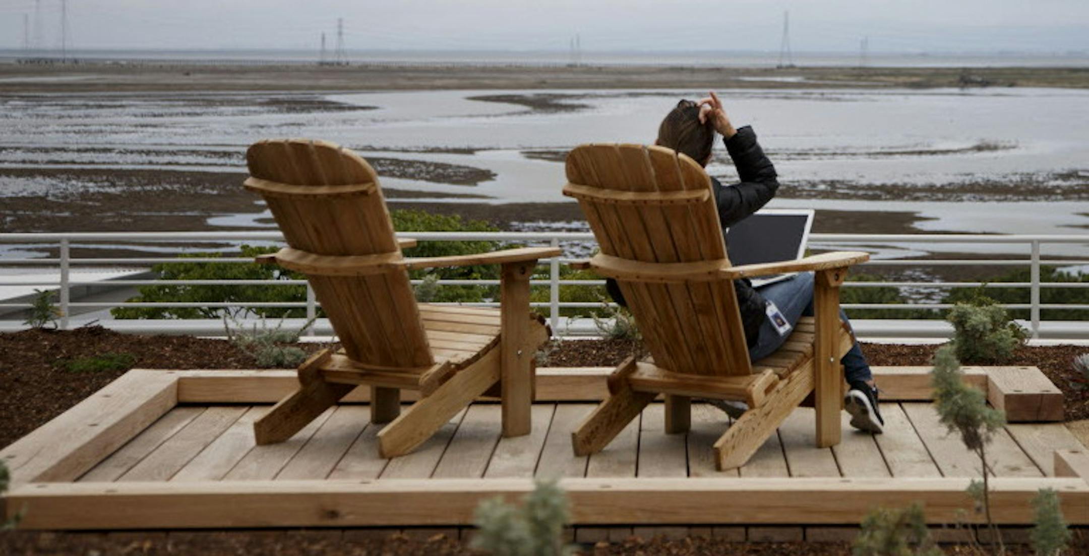 Facebook employee Kim Kamitaki works on a nine-acre green roof above the company‚Äôs new office building in Menlo Park, Calif., on May 22, 2015. The green roof contains a half-mile walking path, chairs and tables for work and various California native plants and drought resistant plants, functioning as a social and work place for employees. (Dai Sugano/Bay Area News Group/TNS) ORG XMIT: 1168629
