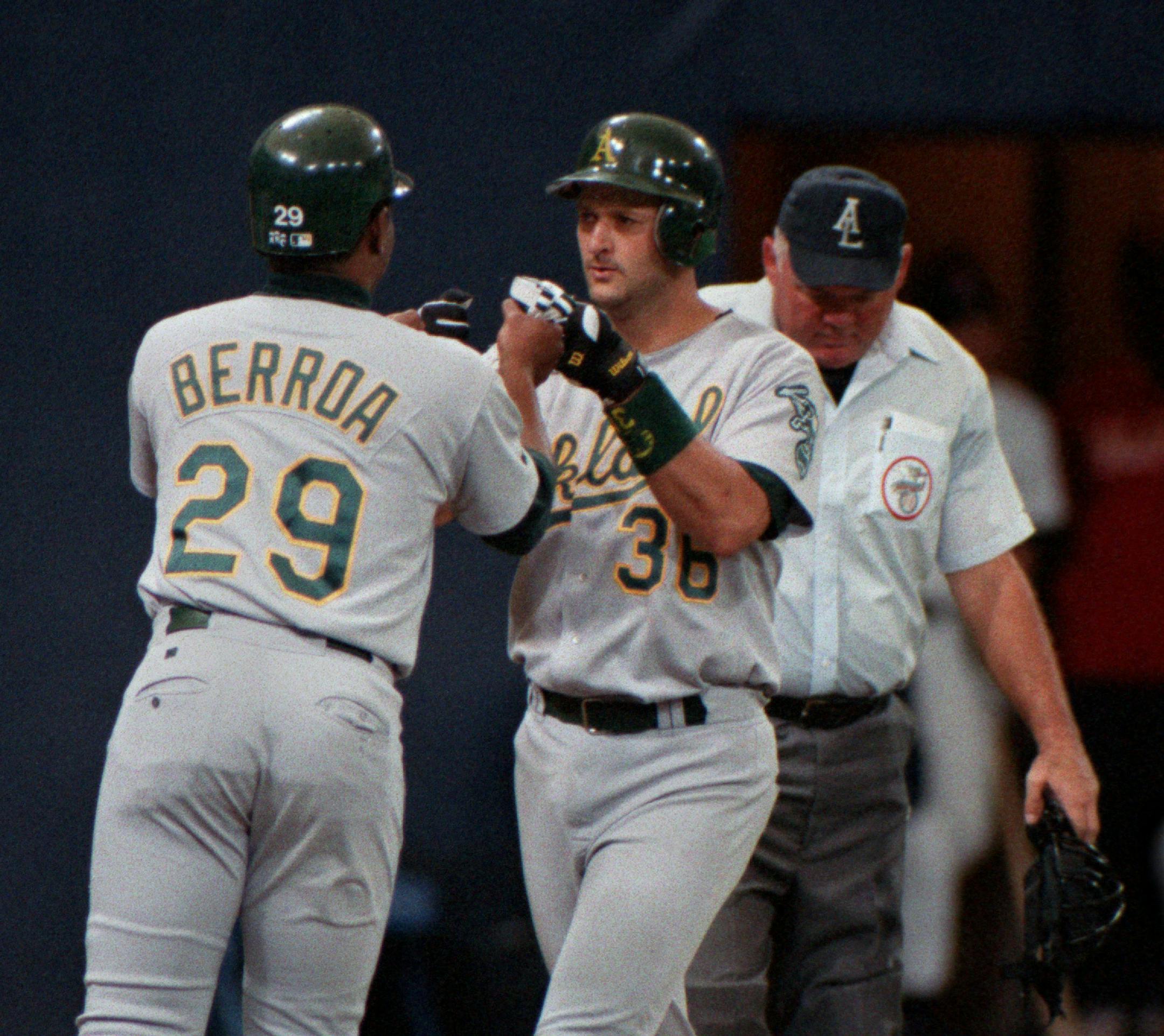 Terry Steinbach gets congratulations from Oakland teammate Geronimo Berroa at the plate after a grand slam home run in the top of the 9th inning.