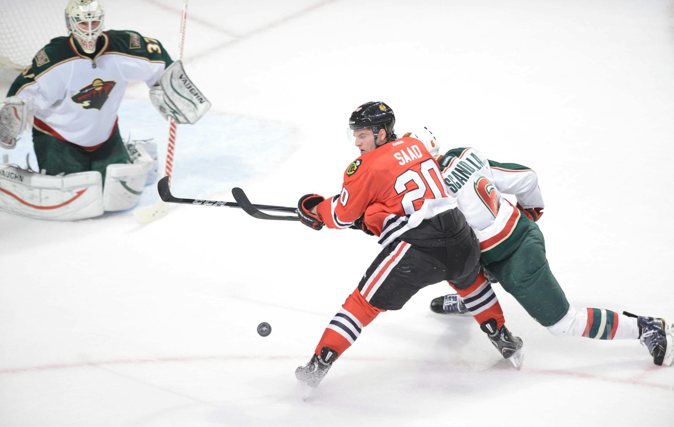 Brandon Saad of the Blackhawks and Marco Scandella of the Minnesota Wild dual for the puck during the first period during Game 2 of an NHL hockey Stanley Cup first-round playoff series in Chicago, Friday, May 3, 2013. The Blackhawks won 5-2. MANDATORY CREDIT, MAGS OUT, TV OUT (AP photo / Daily Herald, Paul Michna )