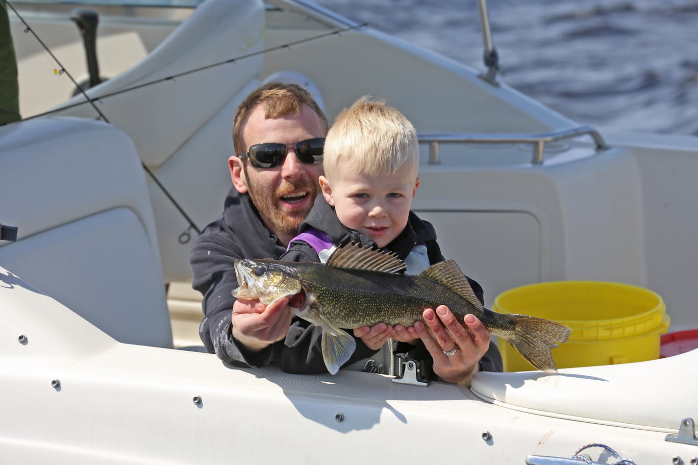 Aaron Hobbs of the Twin Cities area was helped during the fishing opener on Upper Red Lake in May by his son, Erik, 3, as together they showed off one of the walleyes they boated. State fisheries managers are leaning heavily toward a tighter walleye bag limit on Upper Red for the coming winter.