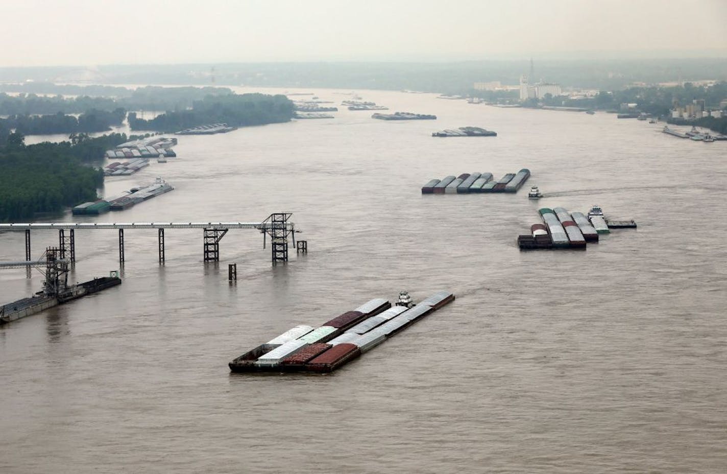 Barge traffic moves north on the Mississippi River just south of St. Louis in late May. Twice this season the U.S. Coast Guard has closed the Mississippi and Illinois Rivers to "all vessel traffic due to extremely high water levels and fast-moving currents" near St. Louis.